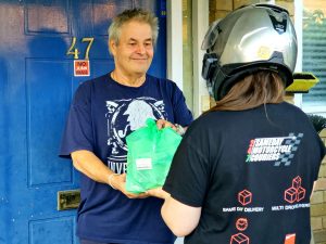 Courier handing a bag of medication to a customer