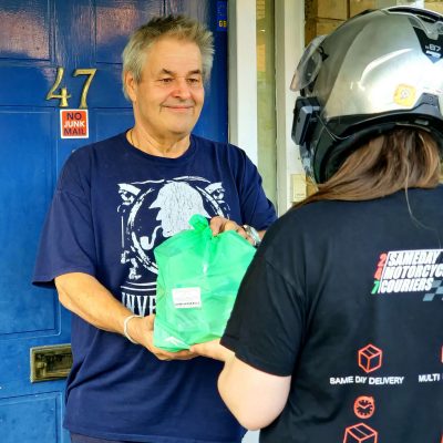 Courier handing a bag of medication to a customer